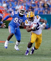 LSU running back Clyde Edwards-Helaire, right, runs past Florida defensive lineman Jachai Polite (99) during the first half of an NCAA college football game, Saturday, Oct. 6, 2018, in Gainesville, Fla.
