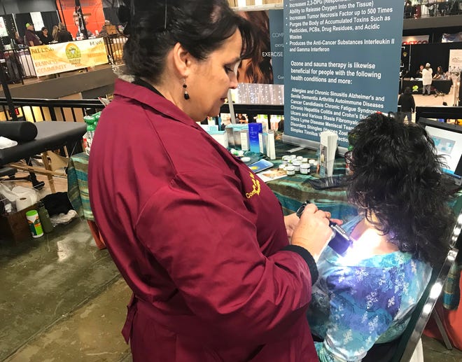Theresa Bryan treats Sabrina McGrane on Sunday during the Redding Health Expo at the Redding Convention Center. More than 100 vendors had booths displaying a wide variety of products and services.