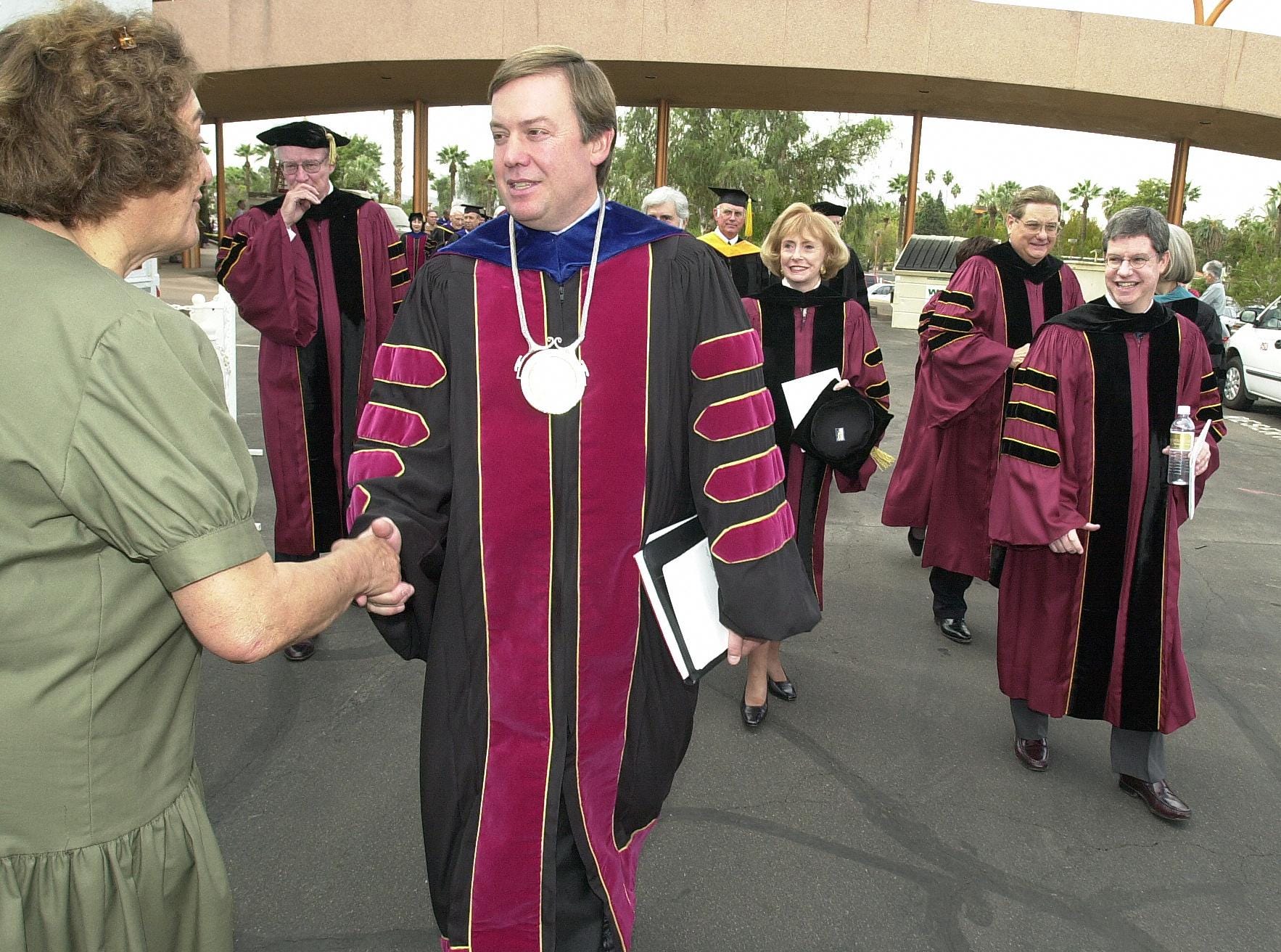 A well-wisher congratulates ASU President Michael Crow after a 2002 inauguration ceremony at the Tempe campus.