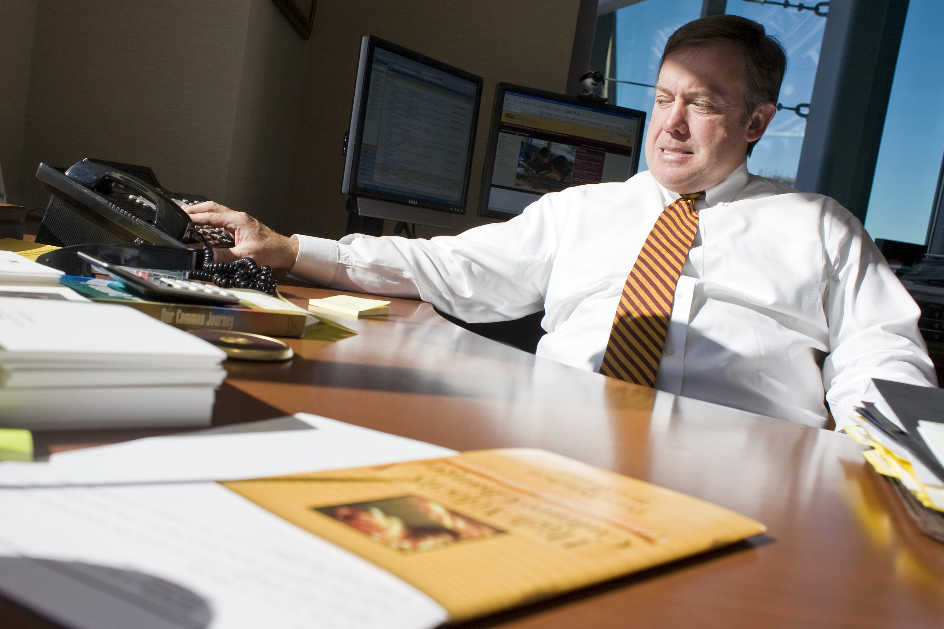 ASU President Michael Crow takes a conference call in his office in 2007.