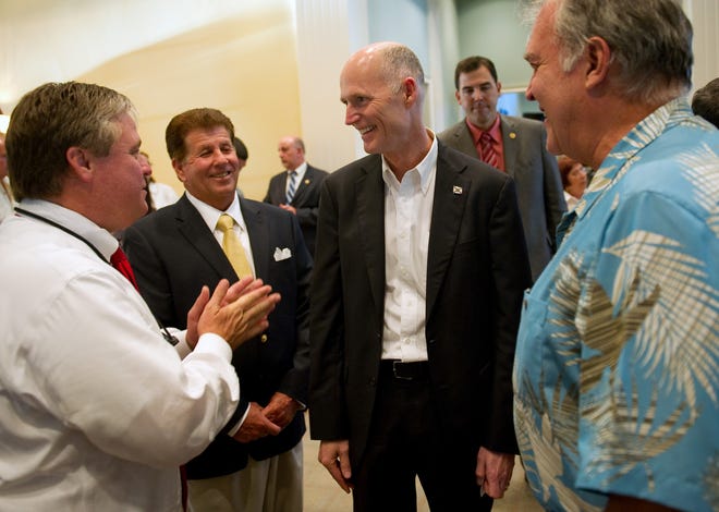 Florida Gov. Rick Scott (second from right) laughs with County Commissioner Wesley Davis (left), Tom Lockwood, chairman of the Indian River County Republican Executive Committee, and Gene Waddell, while visiting The Club at Pointe West for a meet and greet May 1, 2012. In one of Scott's last acts as governor Jan. 7, 2019, he appointed Davis as Indian River County's property appraiser.