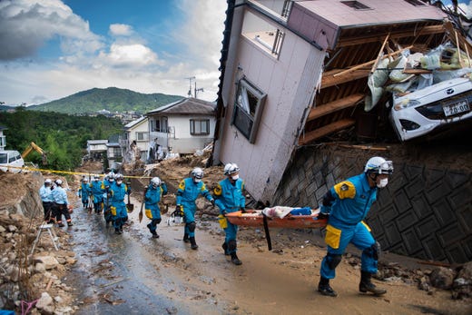Floods and landslides in Japan at the beginning of July were the fifth costliest natural catastrophe in 2018 with $9.5 billion in losses. Police arrive to clear debris scattered on a street in a flood hit area in Kumano, Japan on July 9, 2018.

