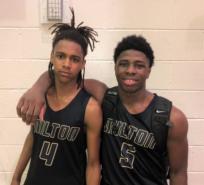 Milton High senior guard Adrian Walker, left, and senior forward Tobias Daniels, right, have helped lead the Panthers into first place in Class 7A-District 1.