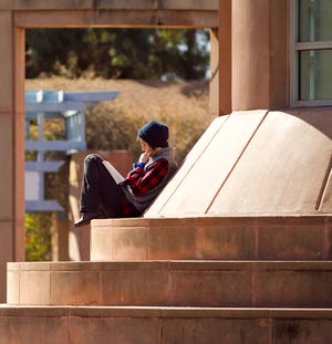 An ASU student studies outside Hayden Library in 2011.