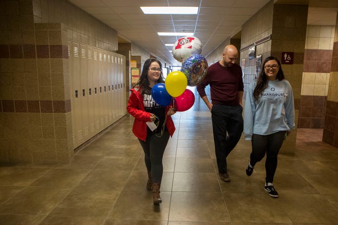 Mia Adams, left, Ryan Kroger and Angelynna Pyeatt deliver balloons to a student at Harrisburg High School, Wednesday, Jan. 9, 2019. The students started their own business, Tiger Balloons, in November 2017.