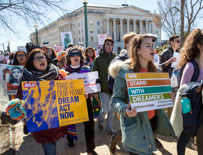 Deferred Action for Childhood Arrivals (DACA) recipients and other young immigrants walk with supporters outside the U.S. Capitol last March, when the program was threatened with extinction by President Trump.