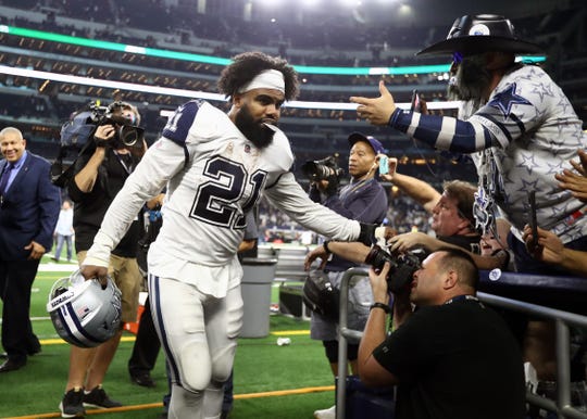 Dallas Cowboys running back Ezekiel Elliott (21) celebrates with fans after a victory against the New Orleans Saints at AT&T Stadium.