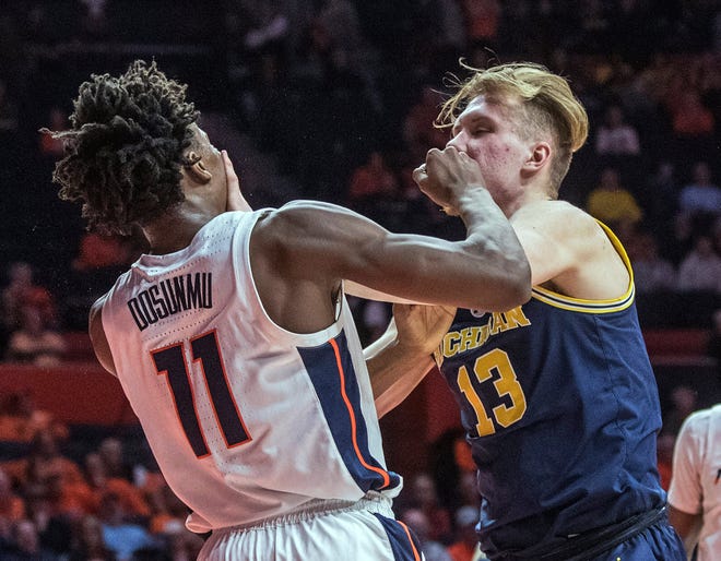 Illinois guard Ayo Dosunmu and Michigan forward Ignas Brazdeikis tangle after a foul during the second half.