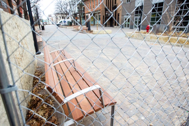 A new bench with handrails is seen through a chain link fence from construction on Friday, Jan. 11, 2019, along the pedestrian mall in downtown Iowa City, Iowa.