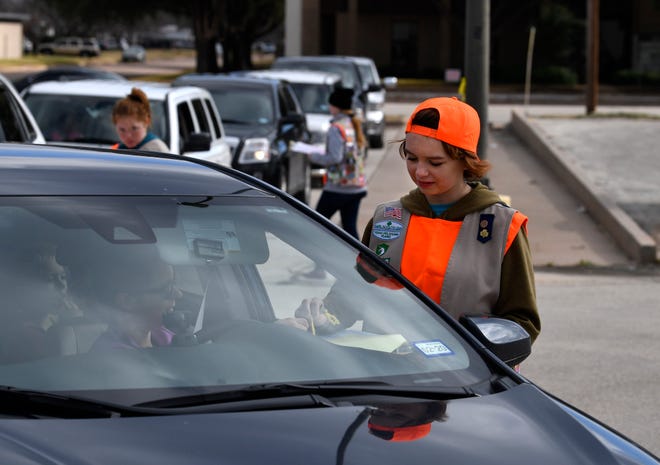 Morgan Medlin, 15, of Abilene, assists helps Girl Scout families fill out paperwork as they pick up their cookie orders Saturday at the Girl Scout office on South Pioneer Drive.