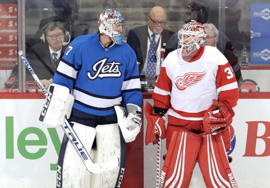 Jets goaltender Connor Hellebuyck talks with Wings goaltender Jimmy Howard during warmups at Bell MTS Place, Jan. 11.