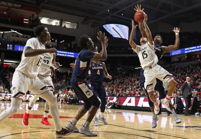 Cincinnati Bearcats guard Cane Broome (15) shoots in front of Connecticut Huskies forward Eric Cobb, rear right, during the first half of a basketball game Saturday, Jan. 12, 2019 in Cincinnati. (Photo by Gary Landers for the Enquirer)