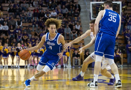 Drake's Noah Thomas dribbles as teammate Nick McGlynn sets a screen on University of Northern Iowa's Spencer Haldeman during Sunday afternoon's game.