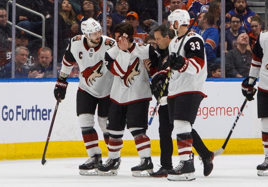 Arizona Coyotes' Conor Garland (83) is helped off the ice after taking a puck to the head during the second period against the Edmonton Oilers on Saturday, Jan. 12, 2019, in Edmonton Alberta. (Jason Franson/The Canadian Press via AP)