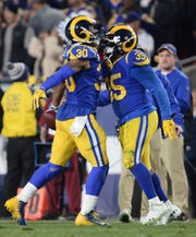 Los Angeles Rams running back Todd Gurley (30) celebrates running back C.J. Anderson (35) after scoring a touchdown against the Dallas Cowboys in the first half in a NFC Divisional playoff football game at Los Angeles Memorial Coliseum.