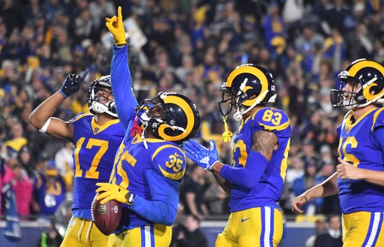 Los Angeles Rams running back C.J. Anderson (35) celebrates with wide receiver Josh Reynolds (83) and wide receiver Robert Woods (17) after scoring a touchdown against the Dallas Cowboys in second quarter in a NFC Divisional playoff football game at Los Angeles Memorial Stadium.