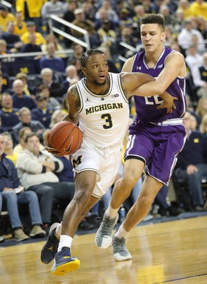 Michigan guard Zavier Simpson drives against Northwestern forward Pete Nance during the first half Sunday, Jan. 13, 2019 at the Crisler Center in Ann Arbor.