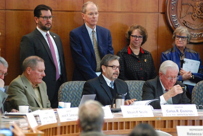 New Mexico lawmakers including Sen. Carlos Cisneros, left, D-Questa, and House Speaker Brian Egolf, upper left, D-Santa Fe, announce a proposal on Monday, Jan. 14, 2019, in Santa Fe N.M. for an 11 percent increase in general fund spending for the coming fiscal year amid a surge in state government income. Most of the new spending would go toward efforts to improve public education as the judiciary threatens to intervene to ensure adequate resources for struggling schools.
