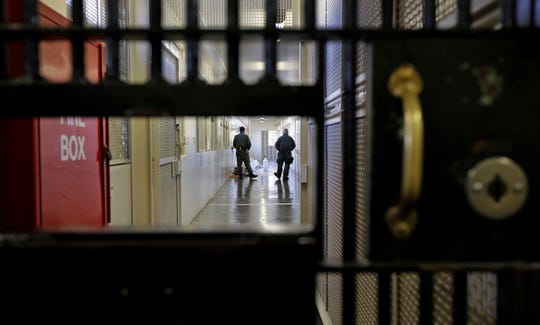 Guards walk a corridor at San Quentin State Prison in San Quentin, Calif.
