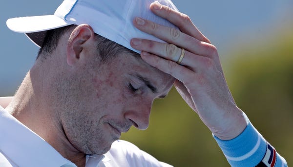 John Isner reacts during his first-round loss to...