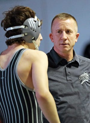 Ankeny Centennial coach Jay Groth speaks with one of his wrestlers during a dual against Ames on Jan. 10, 2019.