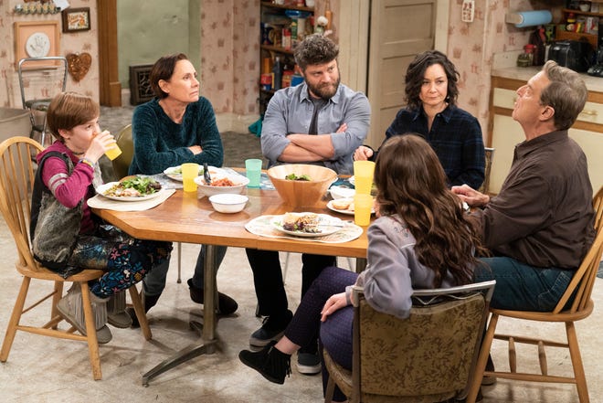 Darlene's beau, Ben (Jay R. Ferguson), third from left, gets the once-over from her family as he joins the Conners for dinner on Tuesday's episode of 'The Conners.'