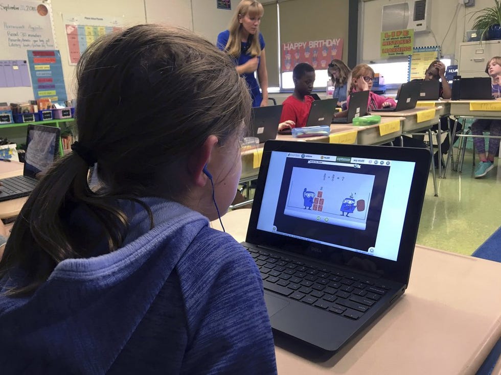 Students at an elementary school in Connecticut work on math problems on a DreamBox while their teacher works with other students in the class.  A wide range of apps, websites and software used in schools borrow elements from video games to help teachers connect with students who live a technology-filled life.
