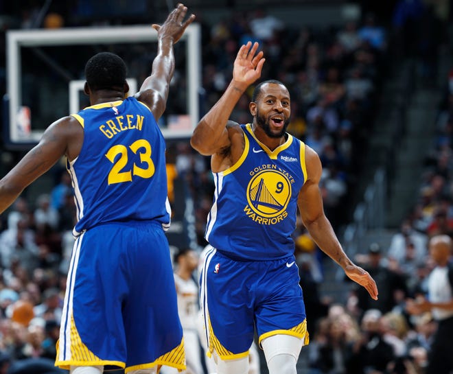 Golden State Warriors forward Draymond Green, left, congratulates guard Andre Iguodala after his dunk against the Denver Nuggets on Tuesday.