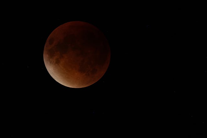 The moon is fully eclipsed in this photo by John Thompson of the lunar eclipse Sept. 27, 2015.