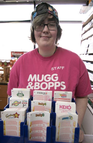 Anna Michels of the Mugg & Bopps Sunoco gas station at 763 S. Michigan Ave. in Howell, poses in front of the lottery tickets Wednesday, Jan. 16, 2019. A winning Lotto 47 ticket was sold there for $3.73 million.