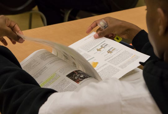 A student of the motors and motor control class flips through the class book for Louisiana Delta Community College's instrumentation programs at the campus in Monroe, La. on Jan. 16. The program focuses on teaching students about the various motors used in manufacturing plants. 