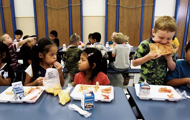 Kindergartners April Ruth Nez, 5, left, Autumn Thompson, 5, and Cooper Collom, 5, eat lunch at the Ruth M. Bond Elementary School cafeteria on Aug. 23, 2013, in Kirtland. The Central Consolidated School District spends more than $160,000 each month to provide meals to students, but it could stop being reimbursed for that amount in April if the federal government shutdown continues.