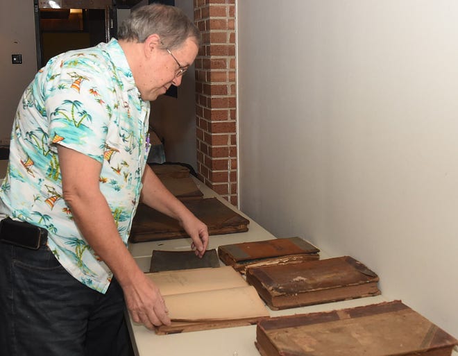 Neal Bertrand browses through vintage ledgers at the monthly meeting of the Imperial St. Landry Genealogical Society.