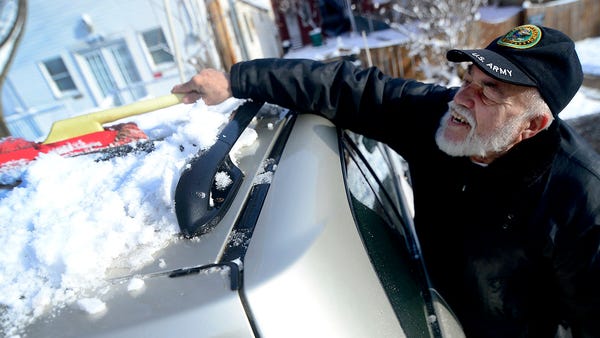 Anibal Maceira, of Hagerstown, Md., cleans snow...