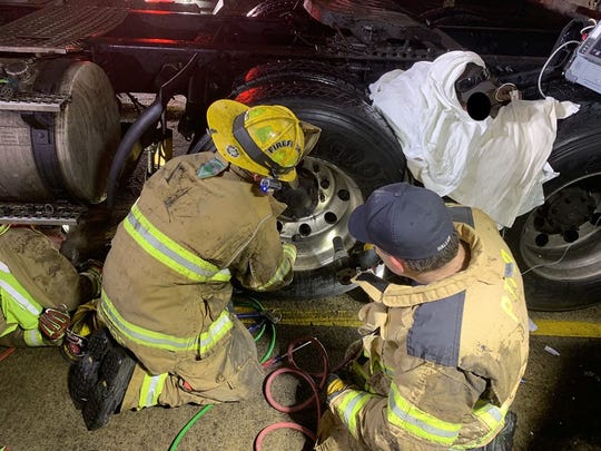 Firefighters working to extricate a man trapped between two semi tires in Plymouth on Jan. 17, 2019. The Livonia Fire Department assisted the Plymouth Twp. Fire Department in the rescue.