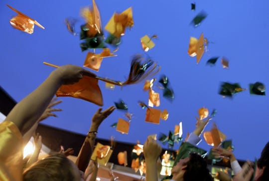 Graduates toss their caps in the air after commencement.