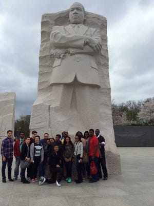 A group of MPS students  gather in Washington D.C. in front of a statue of Martin Luther King Jr. They were participants in the Marching On program.