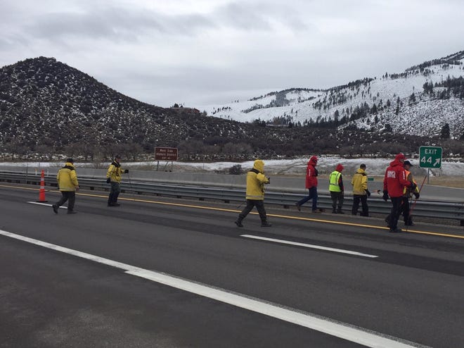 Volunteers for the Washoe County Sheriff's Office's Search and Rescue team walk through the I-580 corridor in search of any evidence linked to the murder of an elderly couple in south Reno.