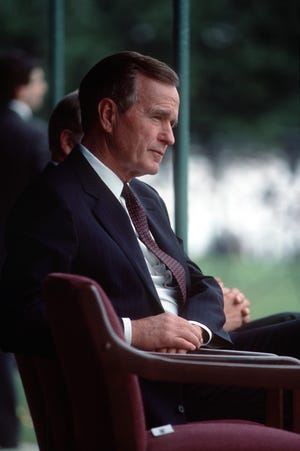 President George H.W. Bush listens to a speech during the retirement ceremony for Admiral William J. Crowe Jr., chairman, Joint Chiefs of Staff.  The ceremony is being held at the US Naval Academy in Annapolis.
