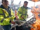 Airport operation workers wearing fluorescent safety jackets flipped burgers and hot dogs on a grill set up on a tarmac in front of a plane at Salt Lake City International Airport, Wednesday, Jan. 16, 2019, in Salt Lake City. In Salt Lake City, airport officials treated workers from the TSA, FAA and Customs and Border Protection to a free barbecue lunch as a gesture to keep their spirits up during a difficult time. (AP Photo/Rick Bowmer) ORG XMIT: UTRB101
