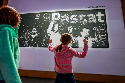 Charlotte Lusk, 6, to the right and her sister, Zoe Lusk, 10, jump and activate the disk screen in the Volkswagen exhibition. His father, Chris Lusk, of George P. Johnson, helped design, during the start of North American International Auto. Show at Cobo Center in downtown Detroit on Saturday, January 19, 2019.