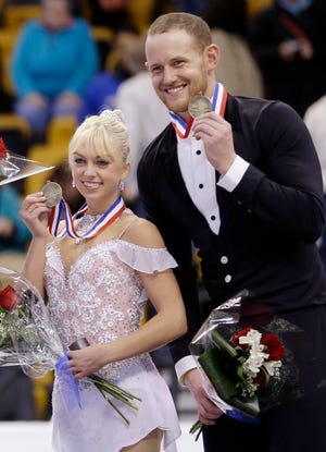 In this Jan. 11, 2014, file photo, bronze medalists Caydee Denney and John Coughlin, of the United States, smile during an award ceremony at the U.S. Figure Skating Championships in Boston. Coughlin, a two-time U.S. pairs champion recently suspended from figure skating, has died.  He was 33.