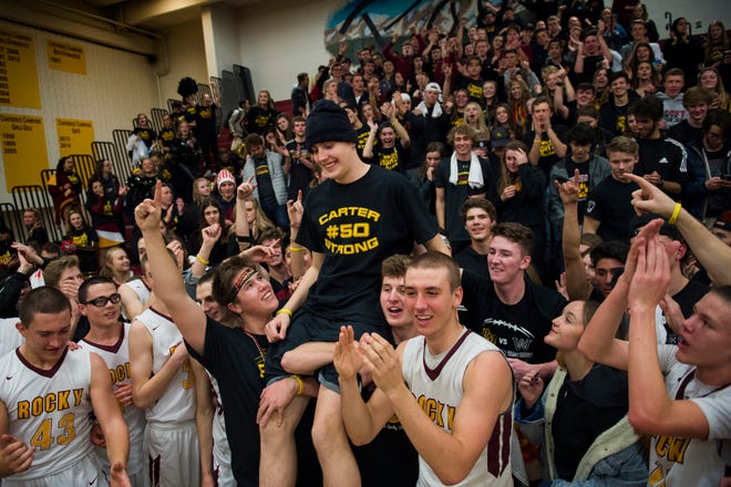 Rocky Mountain High School students hoist up senior Carter Edgerley (50) after a 54-40 win over rival Fort Collins High School on Friday, Jan. 18, 2019, at Rocky Mountain High School in Fort Collins, Colo. 