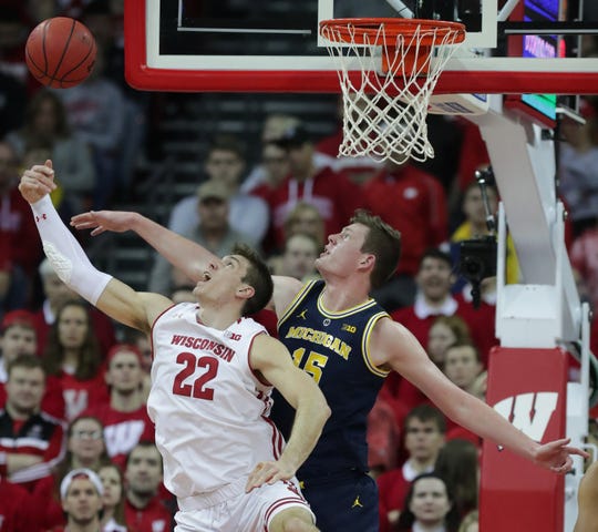 Wisconsin forward Ethan Happ and Michigan center Jon Teske compete for a rebound during the first half Saturday at the Kohl Center in Madison.