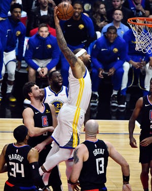 Golden State Warriors center DeMarcus Cousins hangs in the air on his way to a one-handed slam dunk in the first quarter against the Los Angeles Clippers at Staples Center.
