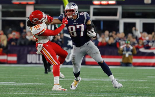 New England Patriots tight end Rob Gronkowski (87) makes a catch and stiff arms Kansas City Chiefs free safety Ron Parker (38) in the second half at Gillette Stadium.