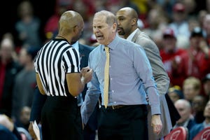 John Beilein of the Michigan Wolverines argues a call with referee Lewis Garrison in the second half against the Wisconsin Badgers.