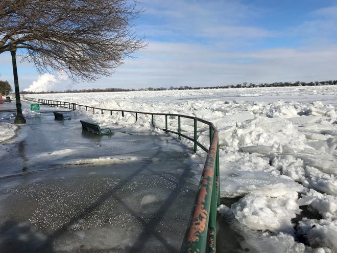 Benches in Marine City are covered in ice spilling over from the St. Clair River.
