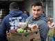 A U.S. Coast Guard member carries a box of free groceries during a food giveaway Jan.  19, 2019 in Novato, Calif. As the partial government shutdown enters its fourth week, an estimated 150 U.S. Coast Guard families in the San Francisco Bay Area, who are currently not being paid, received free groceries during an event organized by the San Francisco-Marin Food Bank and the North Bay Coast Guard Spouses Club.