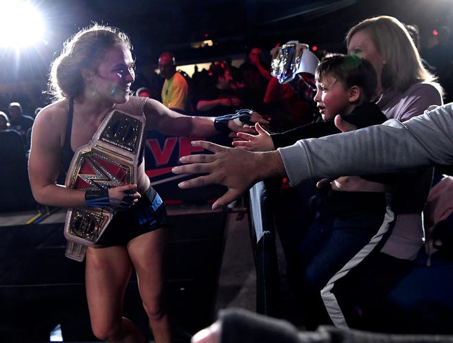 Ronda Rousey briefly takes the hand of 4-year-old Weldon Samford, sitting on the lap of his mother Tammy, after her match during Saturday's WWE Live wrestling event. Held at the Taylor County Coliseum, the evening featured a colorful array of World Wrestling Entertainment stars.